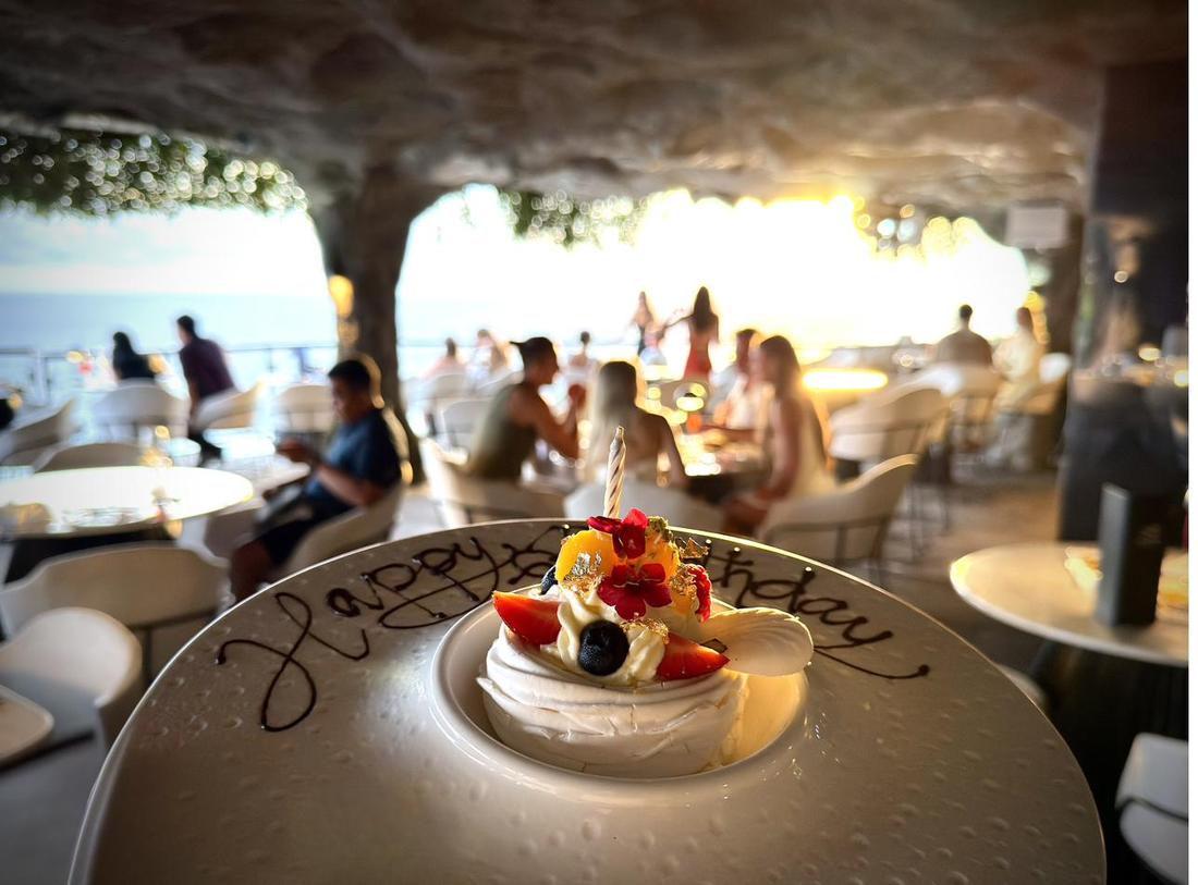 Rockfish Cliffside grotto interior at golden hour with guests celebrating