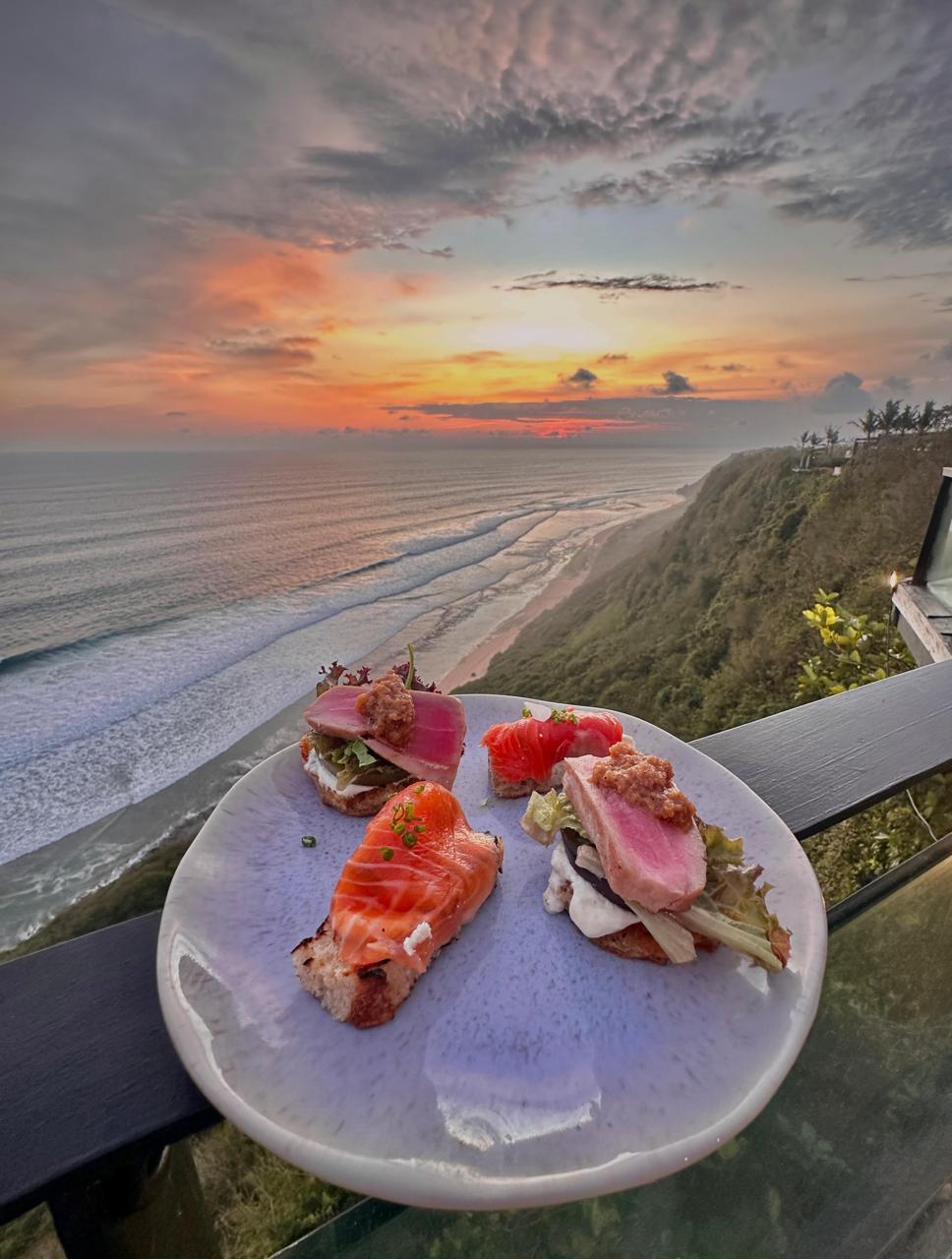 Sunset over Uluwatu beach from Rockfish Cliffside cliff deck