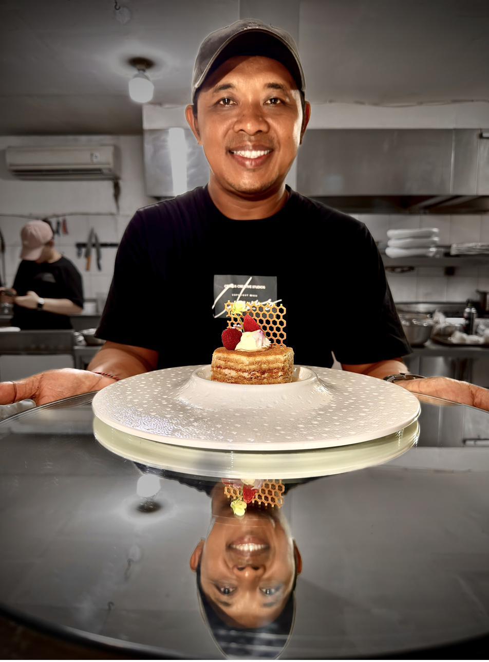 Pastry chef holding Munduk honey cake at Rockfish Cliffside kitchen